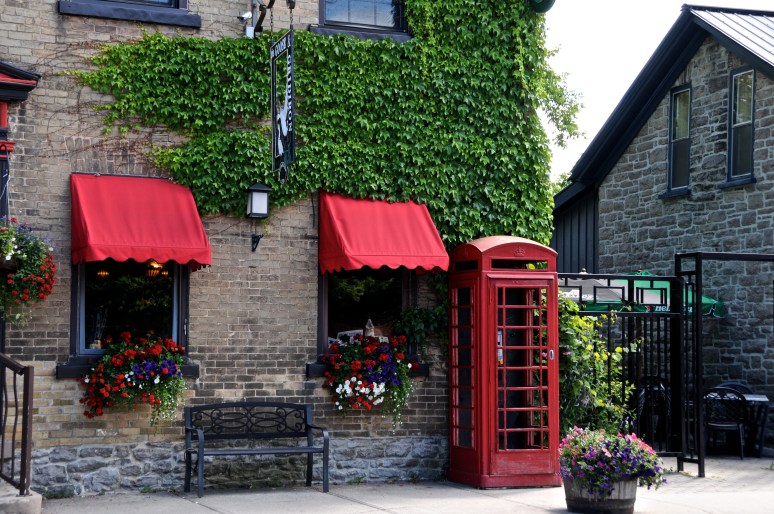 A bright red telephone booth livens up front of a shop on St. Lawrence Steet